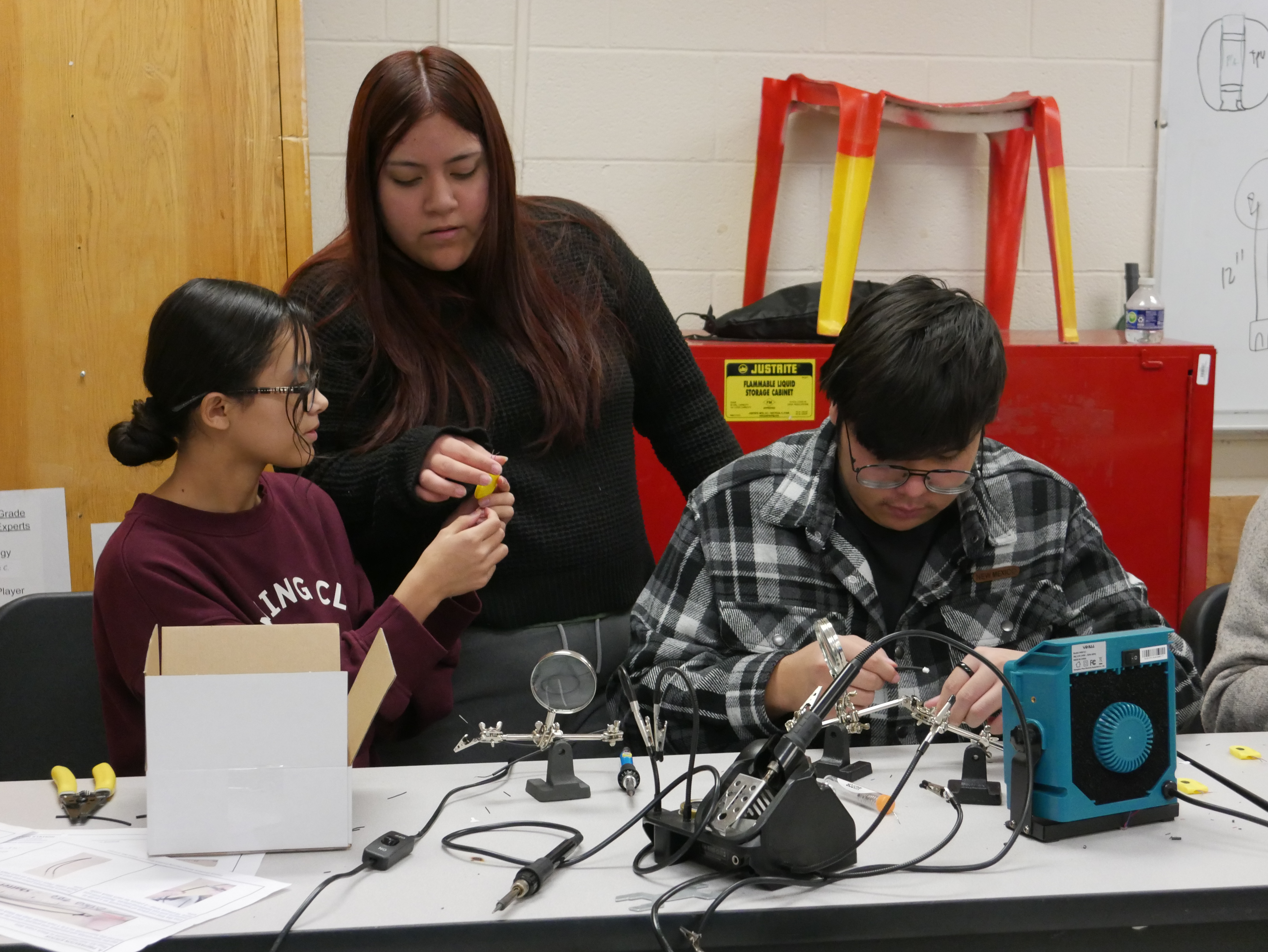 From left: EVHS MESA Students Morgan Sandoval, Jacqueline Arevalo Orozco, and Alexis Hernandez work on a glove's electronics